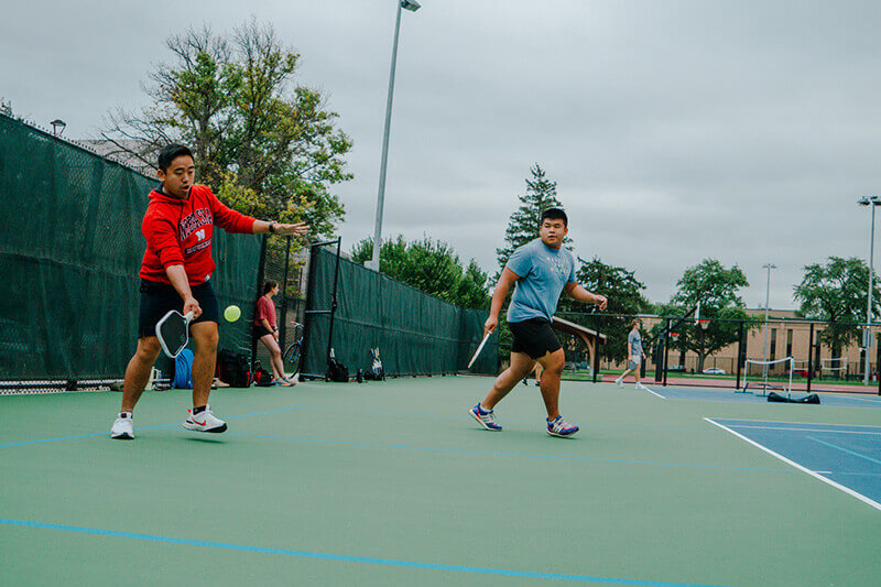 Two men playing doubles in pickleball.
