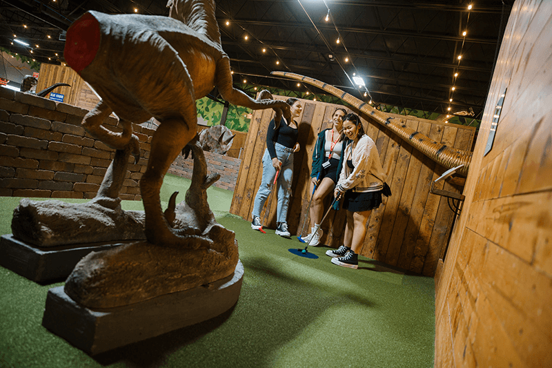 The people playing a hole of mini-golf.